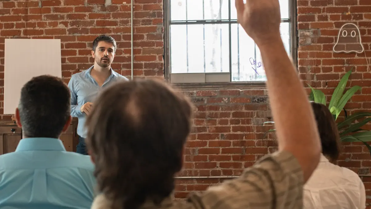 Participant levant la main pour voter lors d'une assemblée générale de copropriété